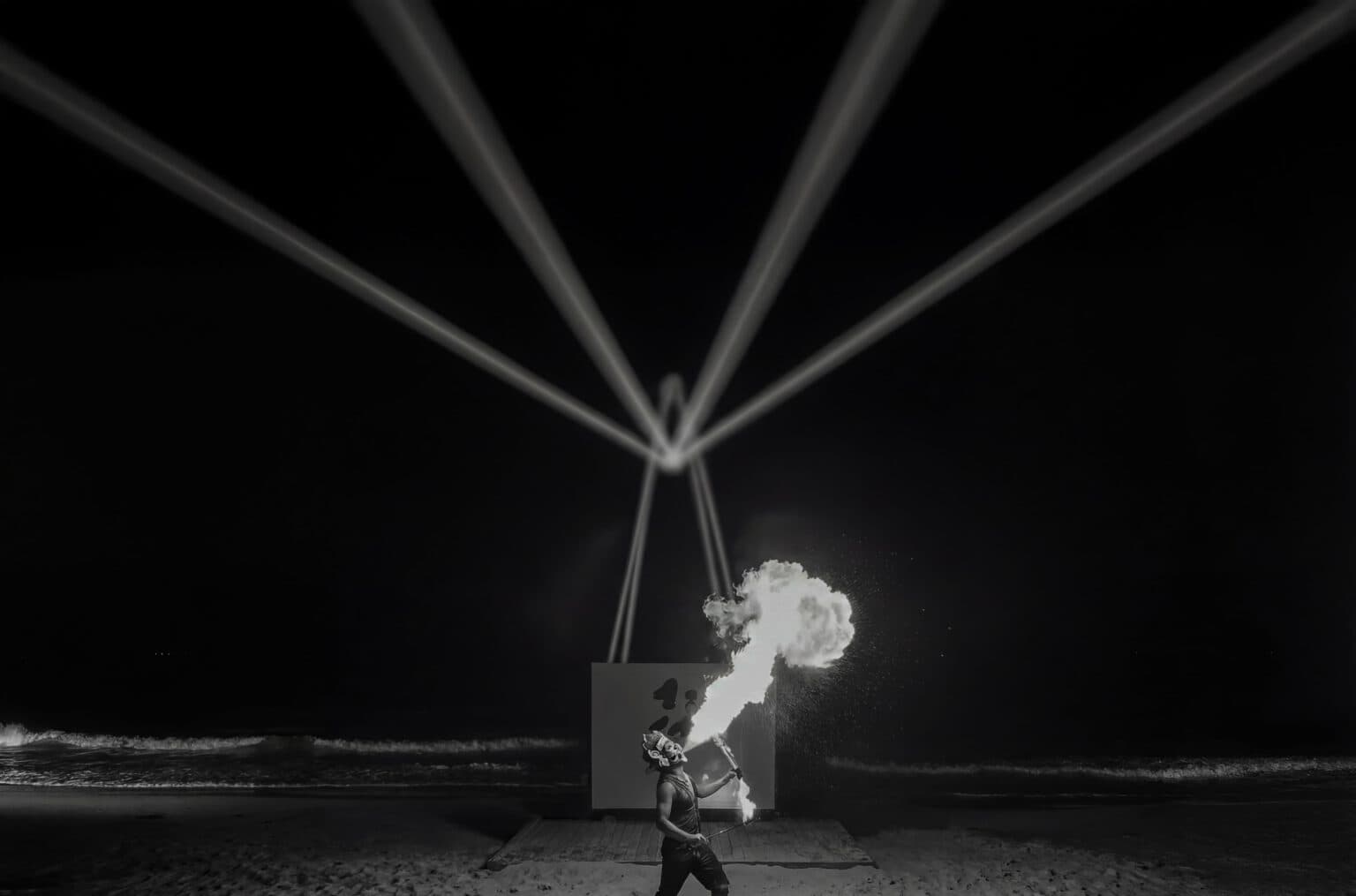 Night beach performance lit by beams of light